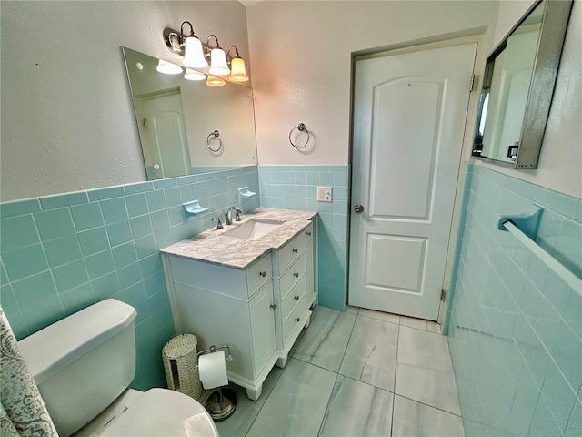 bathroom featuring tile walls, vanity, toilet, and tile patterned flooring