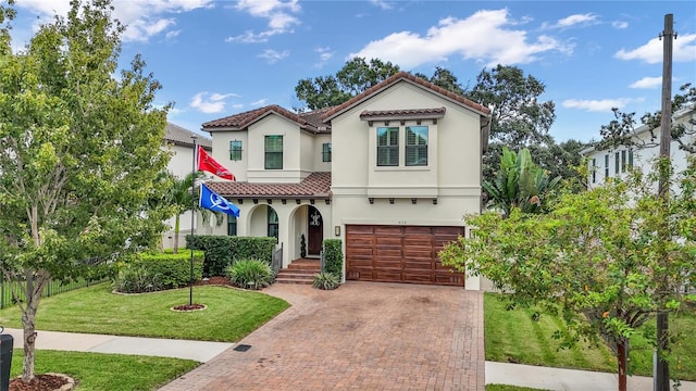 mediterranean / spanish house featuring a garage and a front yard