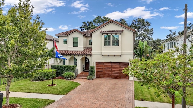 4114 W Zelar St, Tampa, FL 33629 - mediterranean / spanish home featuring decorative driveway, a tiled roof, an attached garage, stucco siding, and a front yard