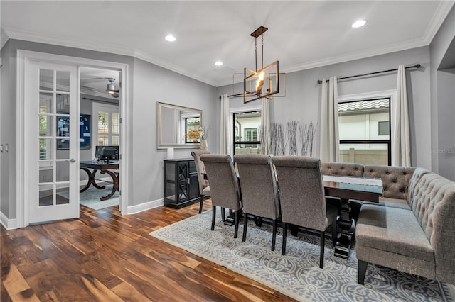 dining room with dark wood-type flooring, ornamental molding, french doors, and a chandelier