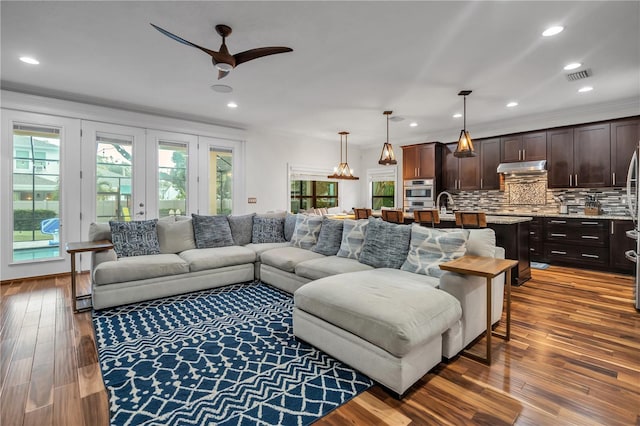 living room with sink, ceiling fan, hardwood / wood-style floors, ornamental molding, and french doors