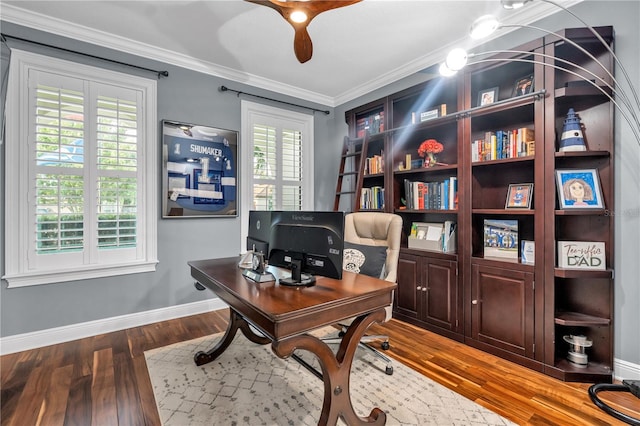 home office featuring wood-type flooring, a healthy amount of sunlight, and ornamental molding