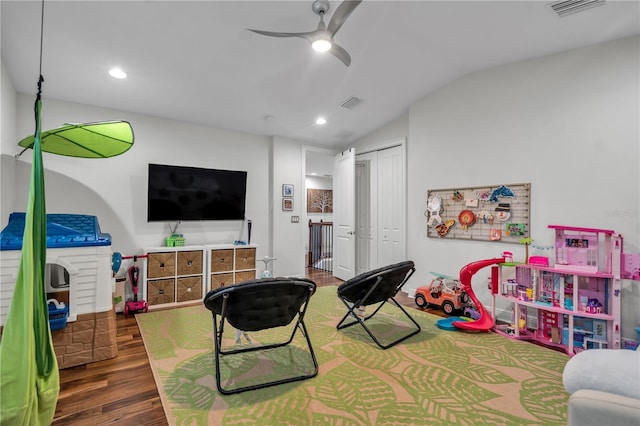 recreation room with lofted ceiling, dark wood-type flooring, and ceiling fan