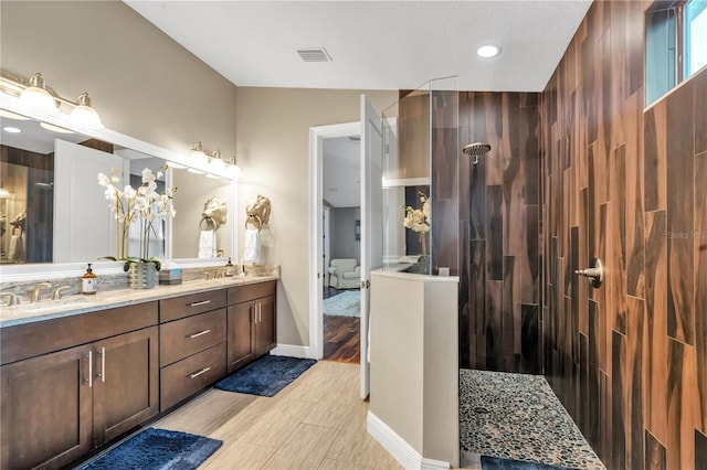 bathroom with vanity and tiled shower