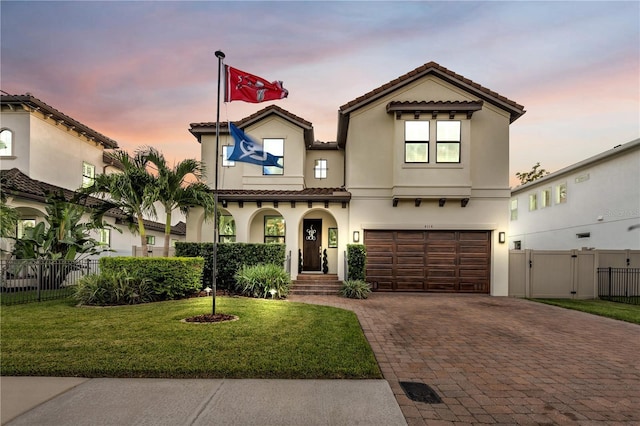 mediterranean / spanish house featuring a garage and a lawn