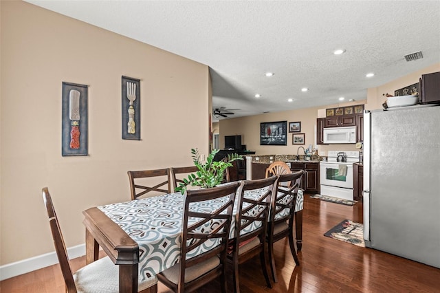 dining area with dark hardwood / wood-style floors, a textured ceiling, and ceiling fan