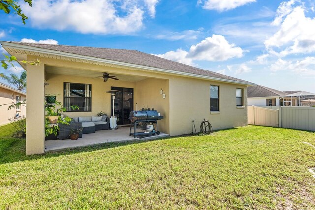 back of property with outdoor lounge area, a yard, a patio, and ceiling fan