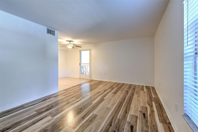 spare room featuring ceiling fan, a textured ceiling, and light hardwood / wood-style flooring