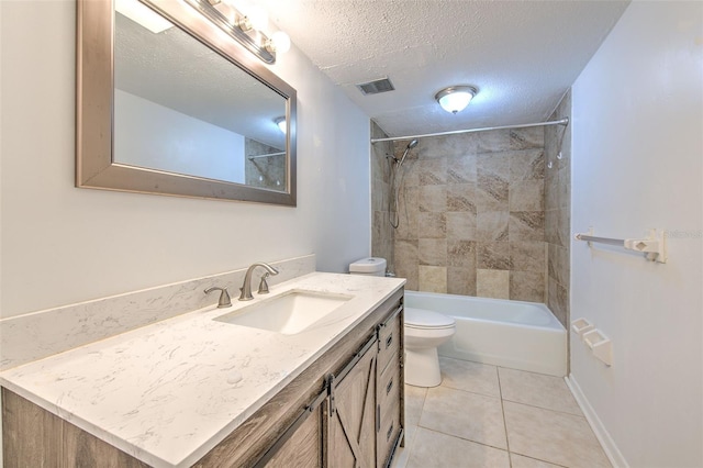 full bathroom featuring a textured ceiling, toilet, vanity, tiled shower / bath combo, and tile patterned floors