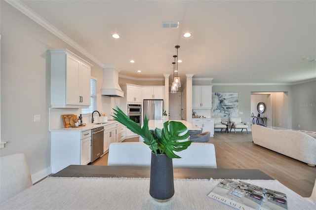 kitchen with custom exhaust hood, white cabinetry, and stainless steel appliances