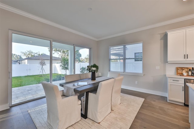 dining space featuring ornamental molding and light wood-type flooring