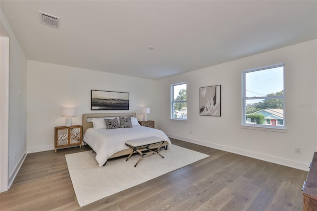 bedroom with multiple windows and hardwood / wood-style floors