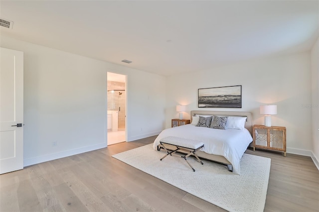 bedroom featuring connected bathroom and light wood-type flooring