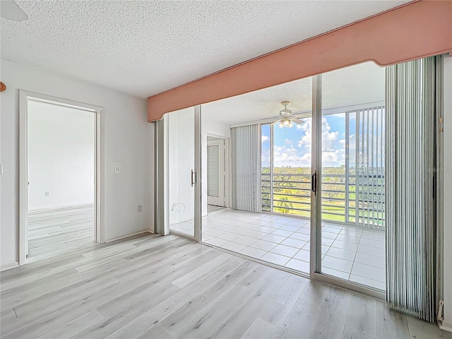 unfurnished bedroom with access to exterior, light wood-type flooring, and a textured ceiling