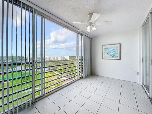 unfurnished sunroom featuring a view of city and a ceiling fan