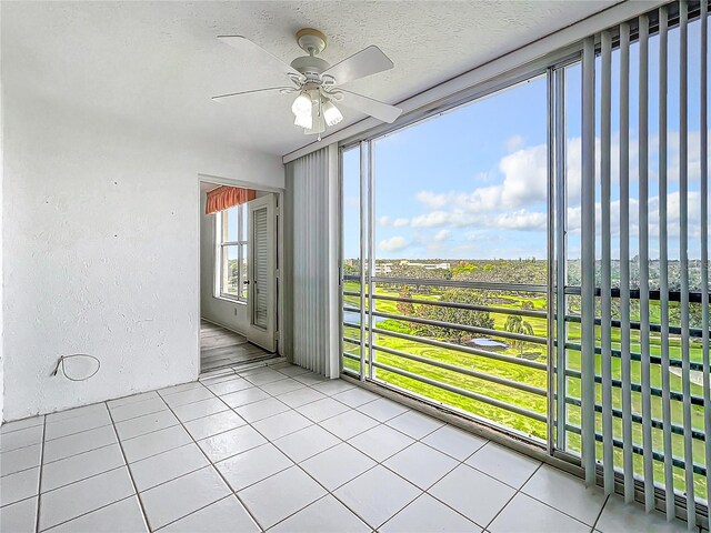 unfurnished sunroom featuring ceiling fan