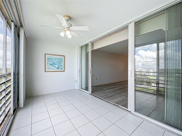 unfurnished sunroom with a wealth of natural light and ceiling fan