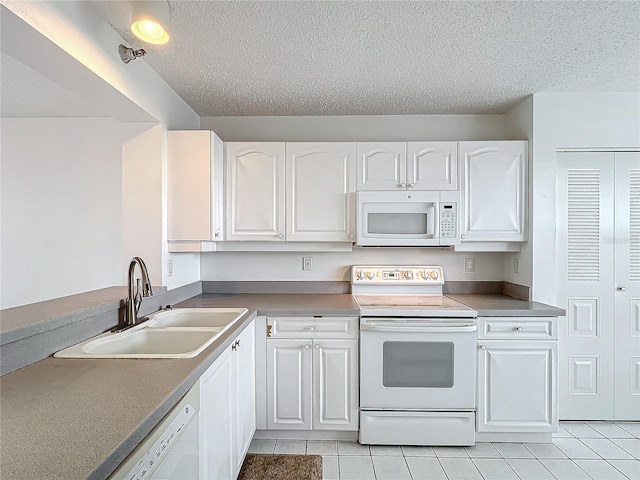 kitchen featuring white cabinetry, white appliances, and a sink