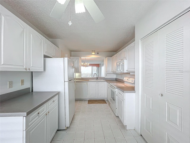 kitchen featuring a sink, white appliances, and white cabinetry