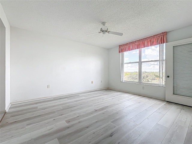 spare room with light wood-type flooring, a textured ceiling, and ceiling fan