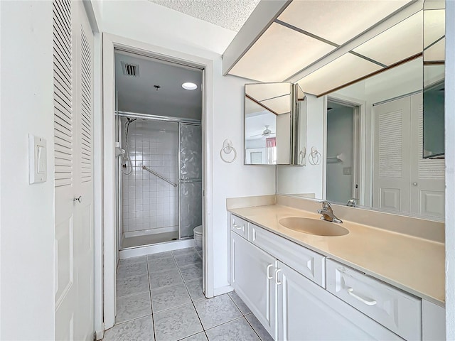 bathroom featuring visible vents, toilet, a stall shower, tile patterned flooring, and vanity