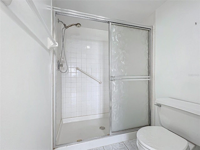 bathroom with a shower stall and toilet