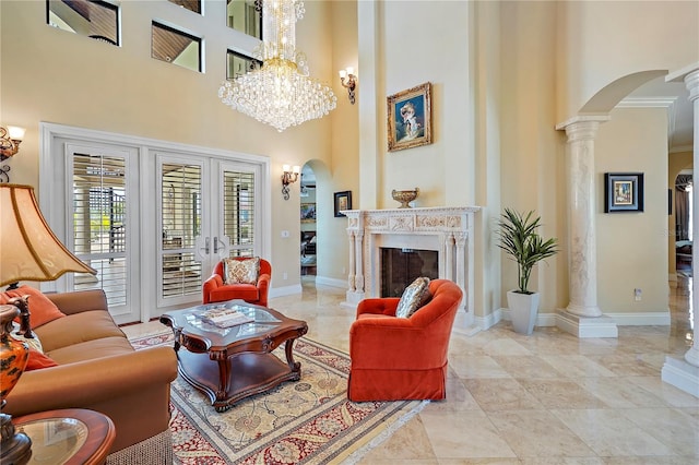 living room with decorative columns, a high ceiling, a fireplace, and ornamental molding