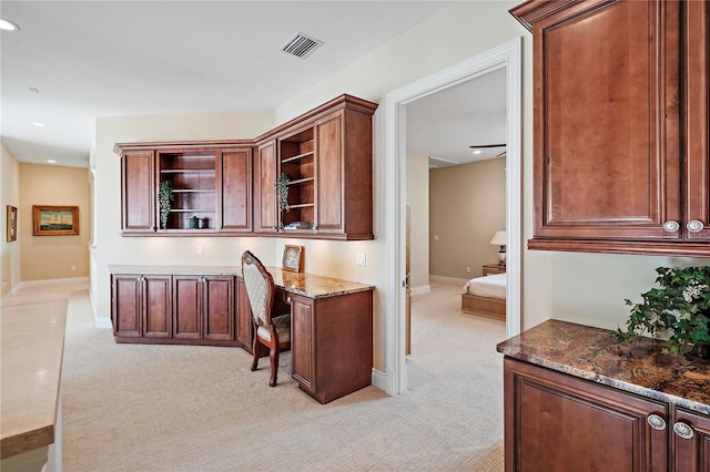 carpeted office space with built in desk