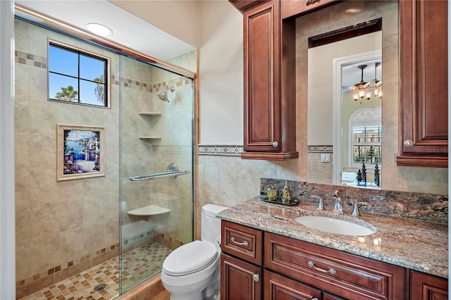 bathroom featuring vanity, toilet, plenty of natural light, and a shower with door