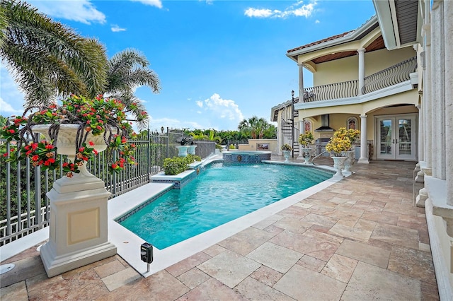 view of swimming pool with a patio area, french doors, and pool water feature