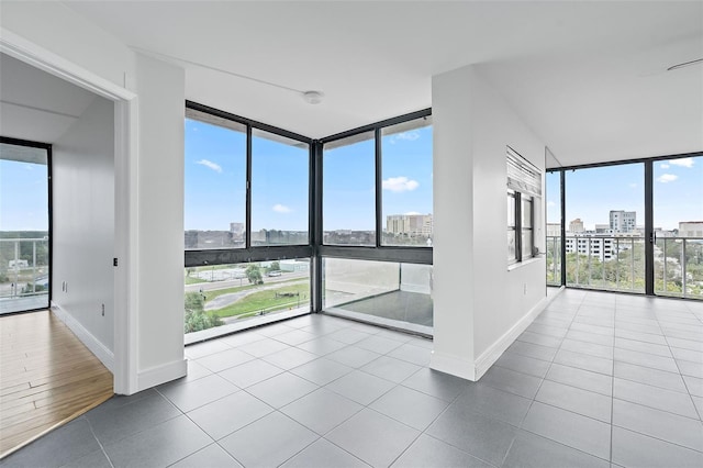 500 N Osceola Ave Unit 802, Clearwater, FL 33755 - tiled empty room featuring a wall of windows, a view of city, and baseboards