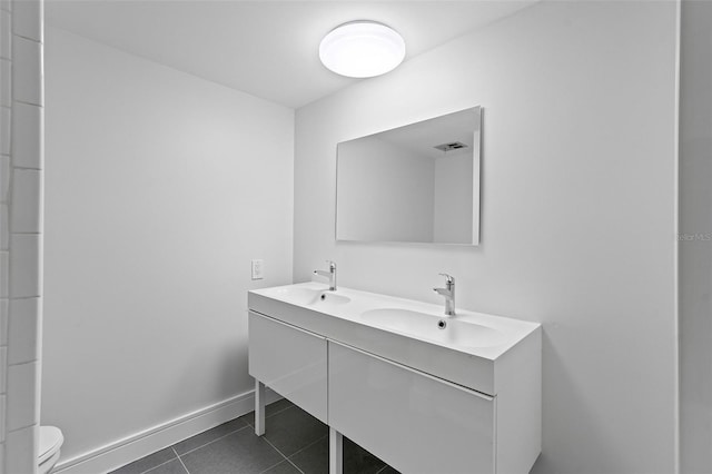 bathroom with toilet, tile patterned floors, and vanity