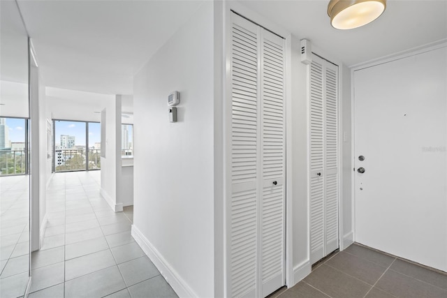 hallway with floor to ceiling windows and tile patterned floors