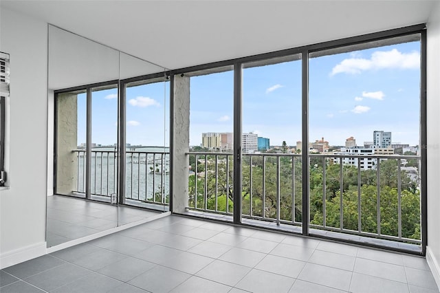 tiled spare room featuring floor to ceiling windows