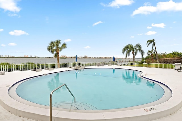 view of swimming pool with a water view and a patio