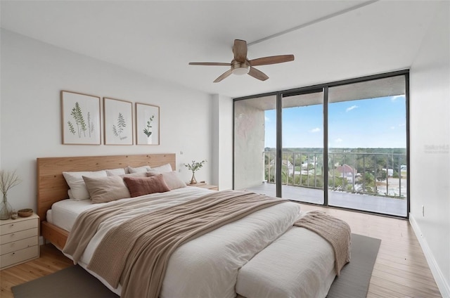 bedroom featuring ceiling fan, a wall of windows, light hardwood / wood-style flooring, and access to outside