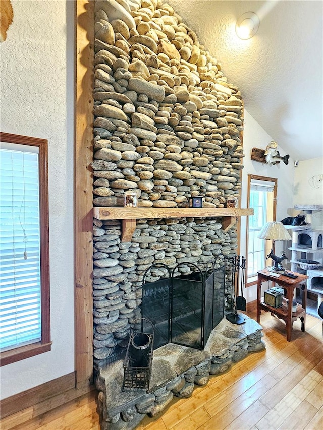 room details featuring a textured ceiling, hardwood / wood-style flooring, and a fireplace