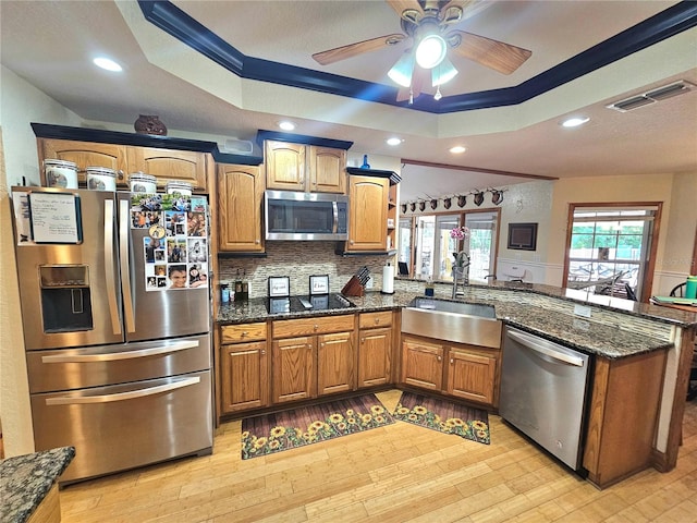 kitchen featuring sink, backsplash, light hardwood / wood-style floors, stainless steel appliances, and crown molding