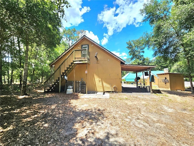 rear view of house with a storage shed and a carport