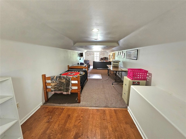 bedroom featuring dark wood-type flooring and vaulted ceiling