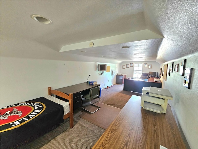 bedroom with a textured ceiling, lofted ceiling, and hardwood / wood-style floors