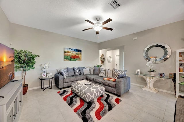 living room with a textured ceiling, light tile patterned floors, and ceiling fan