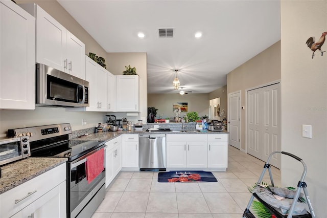 kitchen featuring light stone countertops, sink, kitchen peninsula, white cabinetry, and stainless steel appliances