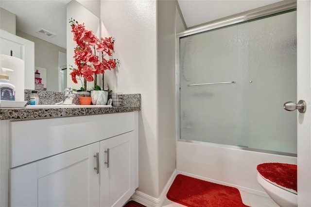 full bathroom featuring toilet, vanity, shower / bath combination with glass door, and tile patterned flooring