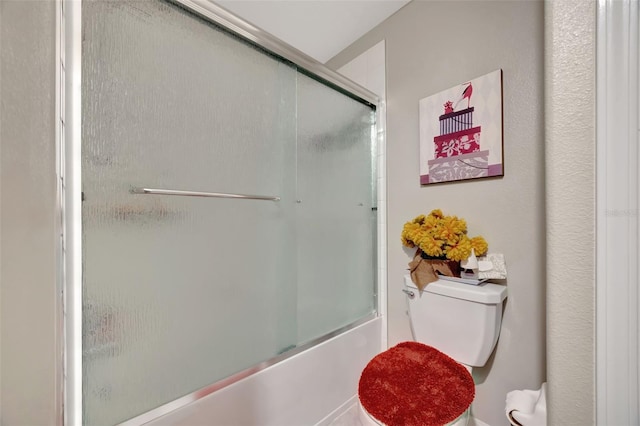 bathroom with bath / shower combo with glass door and toilet