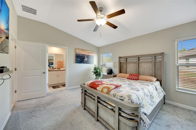 carpeted bedroom with connected bathroom, vaulted ceiling, and ceiling fan