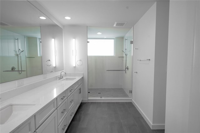 bathroom featuring a shower with door and vanity