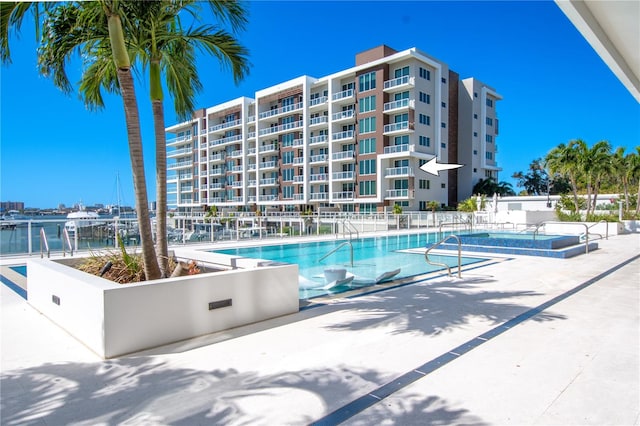 view of pool featuring a patio area and a water view