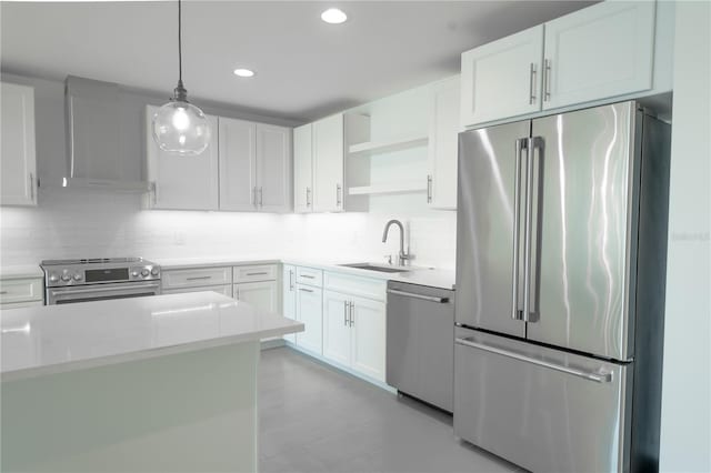 kitchen with wall chimney exhaust hood, white cabinets, hanging light fixtures, and high end appliances