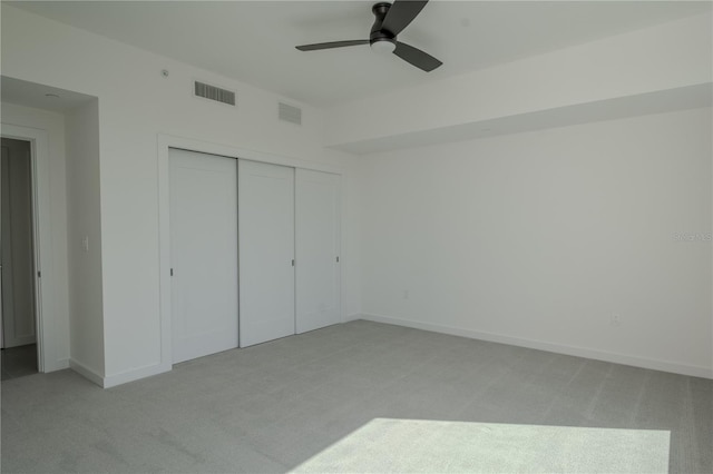 unfurnished bedroom with a closet, ceiling fan, and light carpet